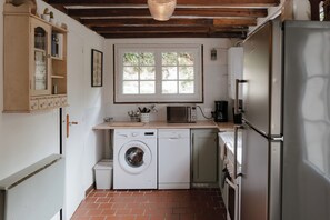 Cucina compatta con lavatrice, microonde e frigorifero.