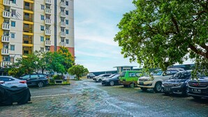 A parking lot with cars and a building in the background. - OYO 92292 Nadjla Property Cibubur Village (Depok)