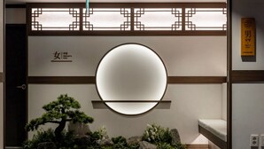 A room with a round mirror, a bed, a small seating area, and a decorative wall with a geometric pattern. - Anook Signature Hotel Incheon Guwol (Incheon)