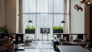 A modern hotel room with a large window, a flat-screen TV, and a dining area with chairs and tables. - Anook Signature Hotel Incheon Guwol (Incheon)