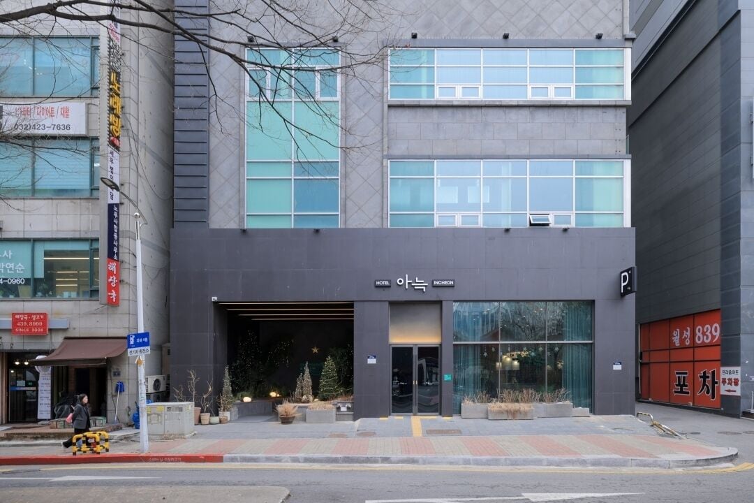 A modern hotel with a dark facade, large windows, and a visible entrance.