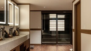 A hotel hallway with a wooden floor, a counter with hair dryers, and a sliding glass door with a grid pattern. - Anook Signature Hotel Incheon Guwol (Incheon)