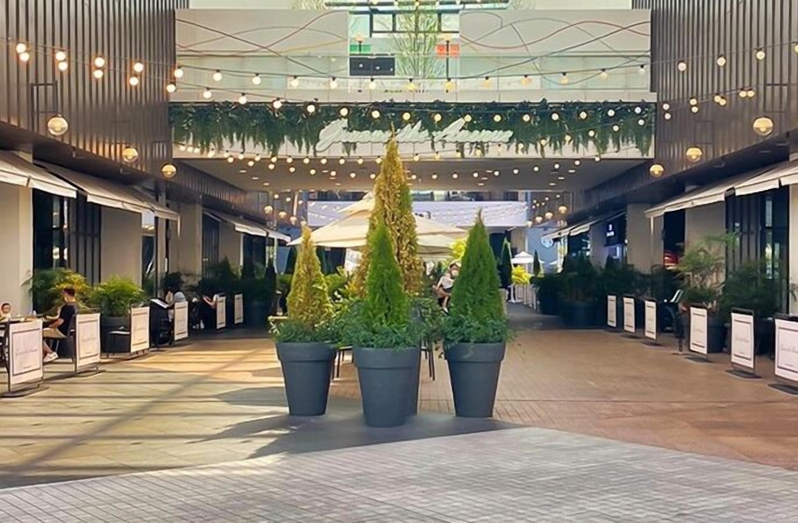 A spacious indoor area with potted plants, seating arrangements, and a modern architectural design.