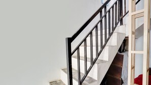 Una escalera con barandilla de metal negro que lleva a una plataforma.