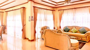 A spacious living room with a sofa set, a coffee table, and a chandelier.