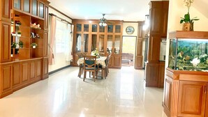 A spacious kitchen with wooden cabinets, a dining area with a table and chairs, and a fish tank.