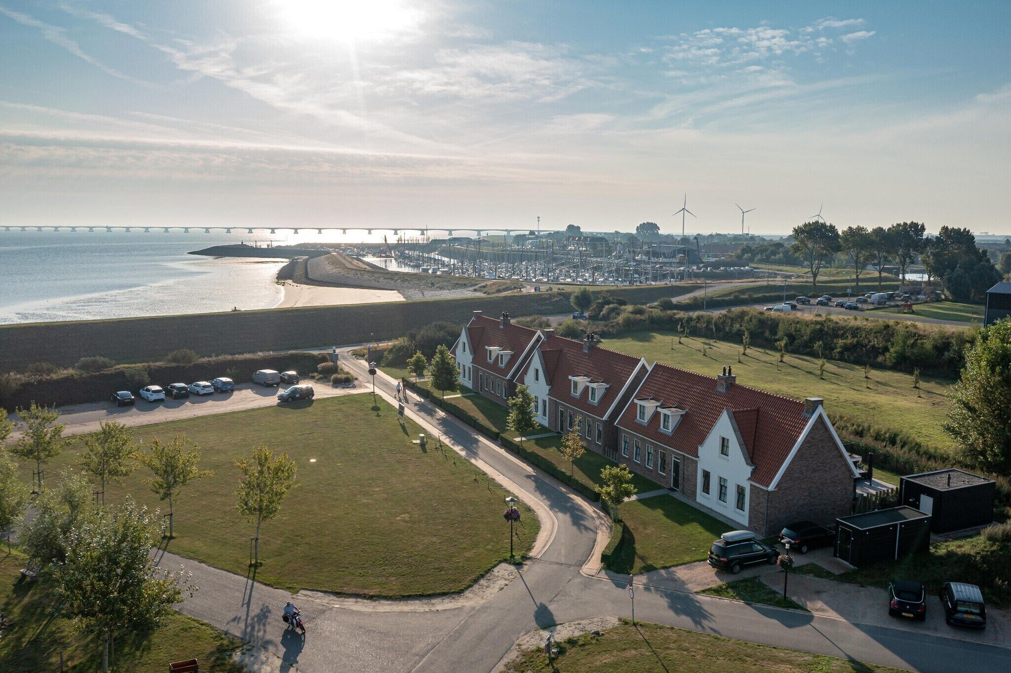 Une zone résidentielle côtière avec des maisons, une plage et un pont en arrière-plan.