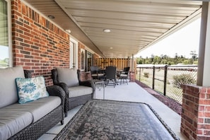 Relax in an outdoor space with a sofa, dining table, and rug.