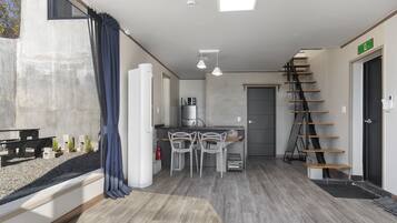 A modern kitchen with a dining area, a staircase, and a view of the outside.