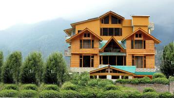 A multi-story wooden building with a symmetrical design, featuring multiple balconies and large windows.