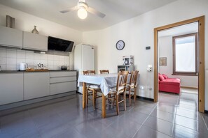 Een moderne keuken met een eettafel, stoelen en een koelkast.