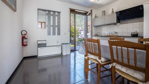 A modern kitchen with a dining area, a ceiling fan, and a fire extinguisher. - Holiday Speed Apartment with Mountain View, Private Terrace, and Wi-Fi (Arco)