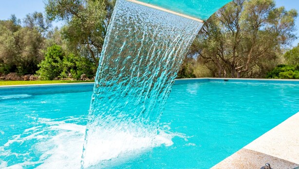 Ein Pool mit einem Wasserspiel im klaren Blickwinkel.