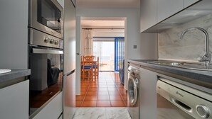 A compact kitchen with a built-in oven, a washing machine, and a sink. - Holiday Home 'Casa Vistamar' with Sea Views, Private Pool and Wi-Fi (Almuñecar)