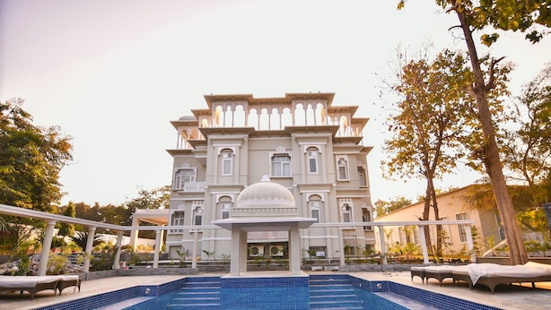 Ein großes Gebäude mit Schwimmbad und Liegestühlen.