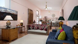 Un salon avec un canapé, une table, une lampe et un tableau au mur.