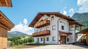 Un edificio de varios pisos con balcones de madera, un letrero que dice 'Morobesthof' y un paisaje montañoso al fondo.