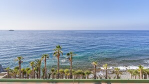 A coastal view with palm trees and a clear blue sky. - Vacation Apartment 'Epsilon 2 4f Primera Línea De Playa' with Sea View & Shared Pool (Almuñecar)