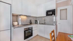 A compact kitchen with white cabinets, a microwave, a toaster, and a coffee maker. - 'Pine Walk' Apartment with Sea Views, Wi-Fi and Air Conditioning (Pollensa)