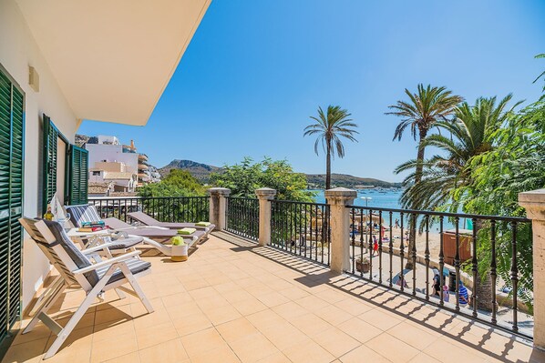 A balcony with sun loungers, a view of the sea, and a railing.