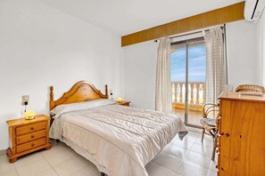A bedroom with a bed, wooden nightstand, dresser, and a balcony with a view. - Holiday Apartment 'Barlovento I' with Sea View, Terrace, Shared Pool & Wi-Fi (Xeraco)