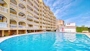 A hotel with a swimming pool, multiple balconies, and a clear blue sky. - Holiday Apartment 'Barlovento I' with Sea View, Terrace, Shared Pool & Wi-Fi (Xeraco)