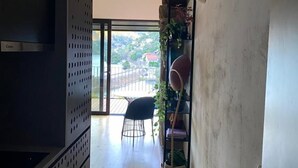 Una cocina moderna con horno empotrado, una silla negra y una estantería con plantas.