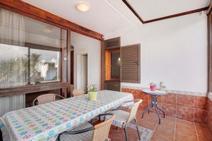 Un comedor con una mesa, sillas, una planta en maceta y una mesita con un adorno.