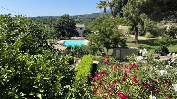 A pool surrounded by lush greenery and a clear blue sky. - Petit Villa Climatise A Moriani Plage (San-Nicolao)