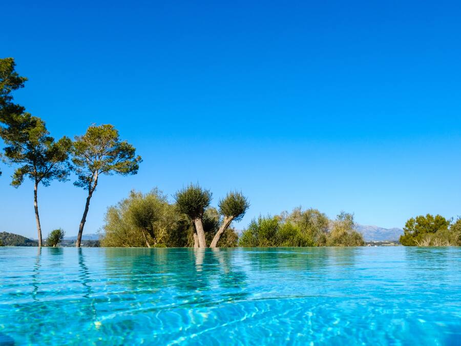 Una piscina cubierta, una piscina al aire libre, sombrillas, tumbonas