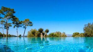 Una piscina cubierta, una piscina al aire libre, sombrillas, tumbonas
