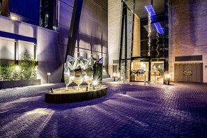 A modern building entrance with a glass facade, a central sculpture, and a sign indicating a no standing zone. - Melbourne by the window - Luxury stay (South Yarra)