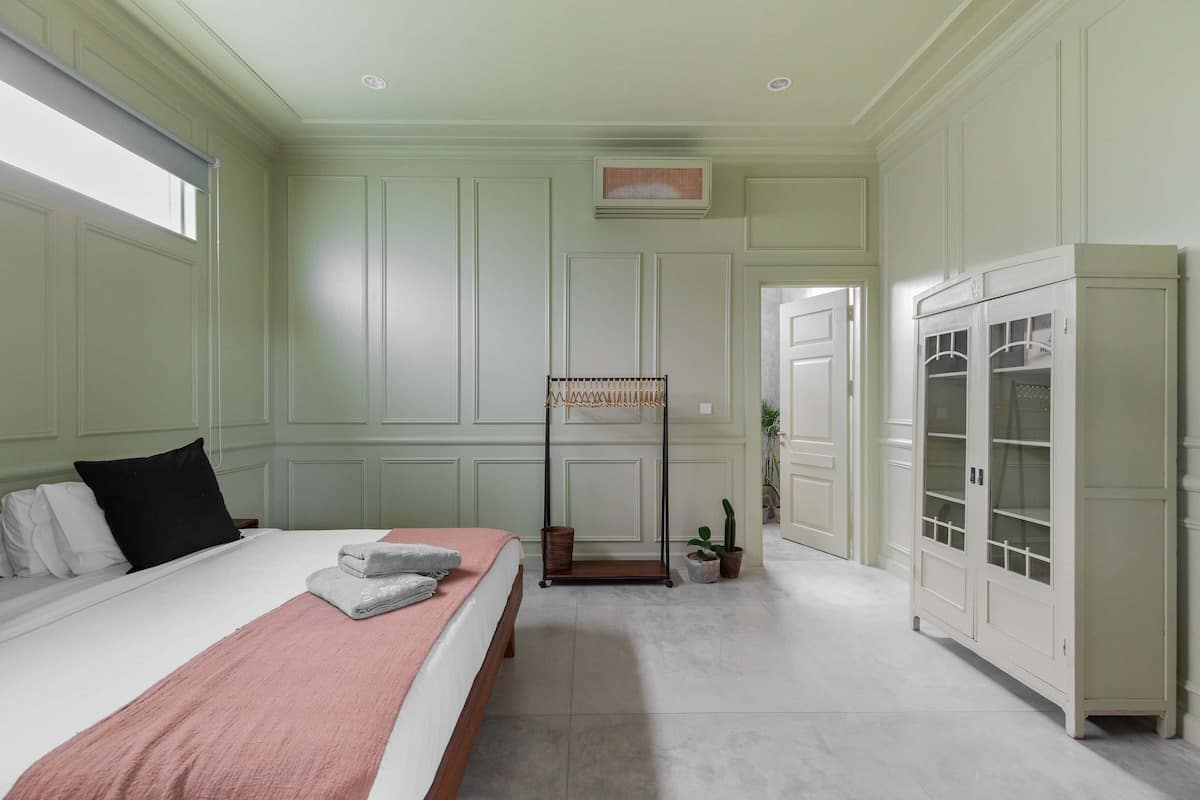 A bedroom with a bed, bedside table, and a wardrobe.