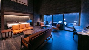 A modern hotel room with a large bed, a sofa, a desk, and a balcony with a view. - yumotoankiyohime (Kirishima)