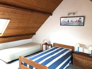 2 dormitorios y tabla de planchar con plancha