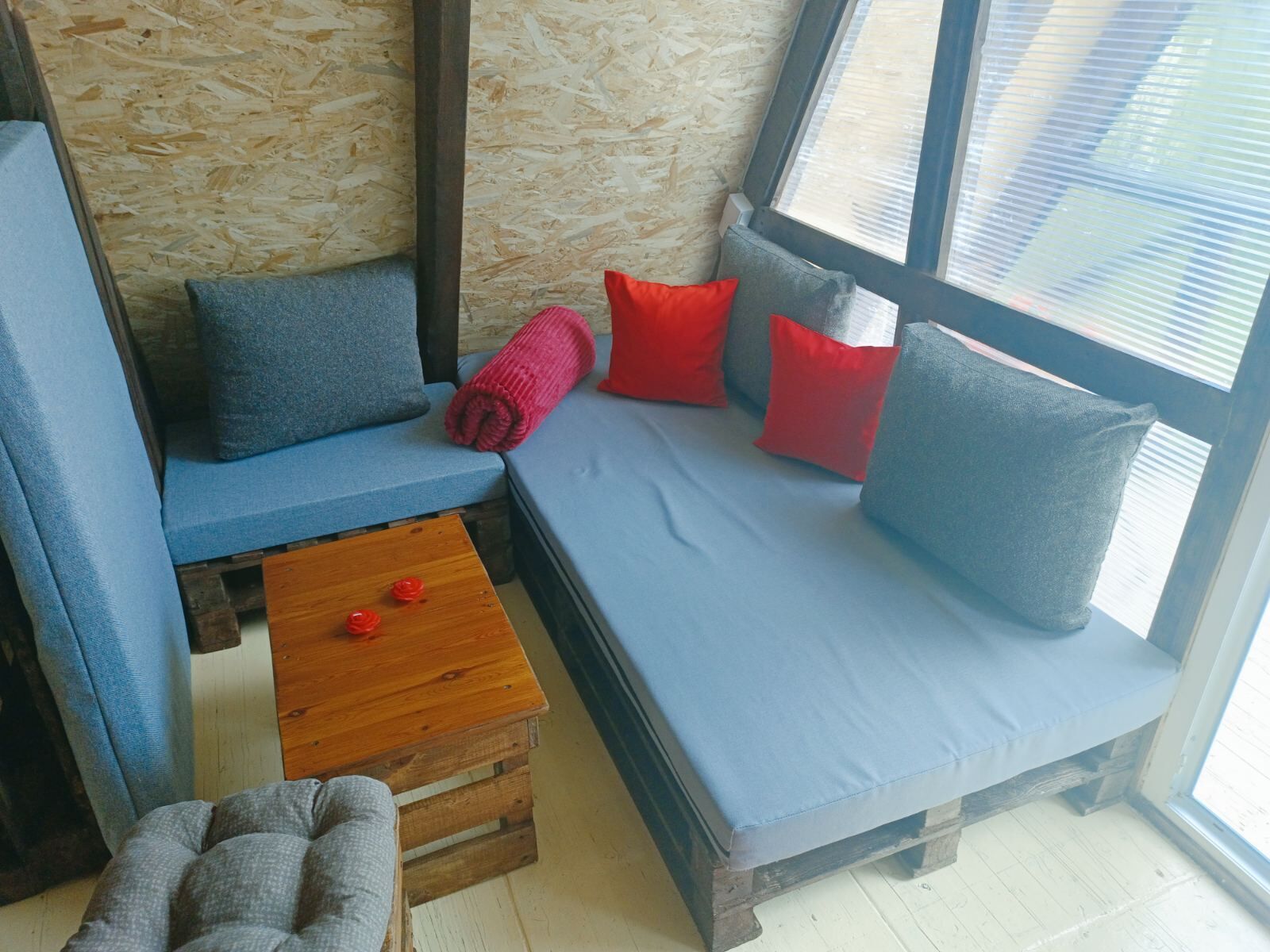 A cozy seating area with a blue sofa, a wooden coffee table, and a grey armchair.
