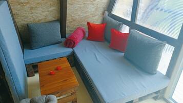 A cozy seating area with a blue sofa, a wooden coffee table, and a grey armchair.