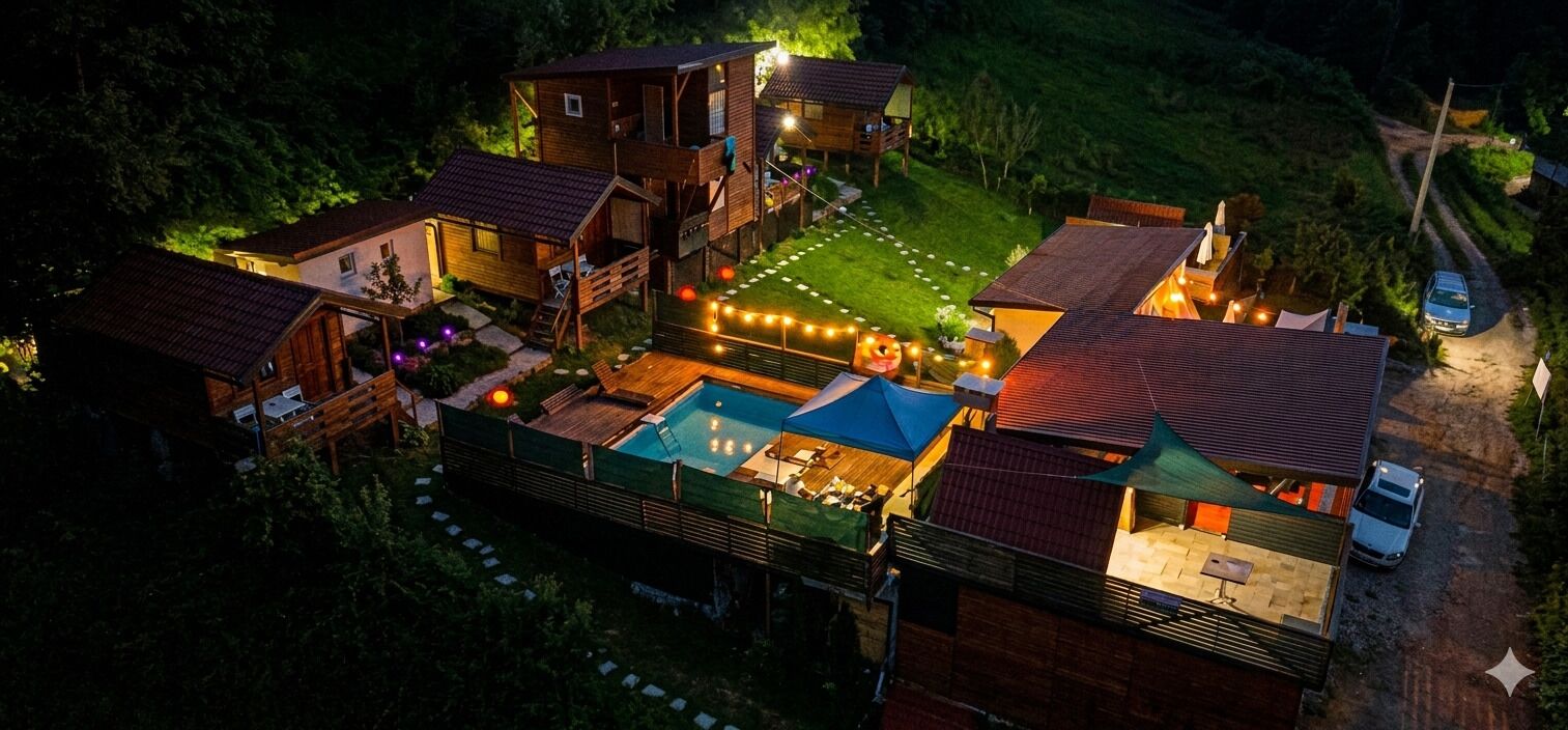 A multi-story wooden cabin complex with a swimming pool, surrounded by a well-maintained lawn and a dirt path.