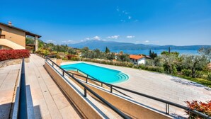 A swimming pool with a view of mountains and a lake.