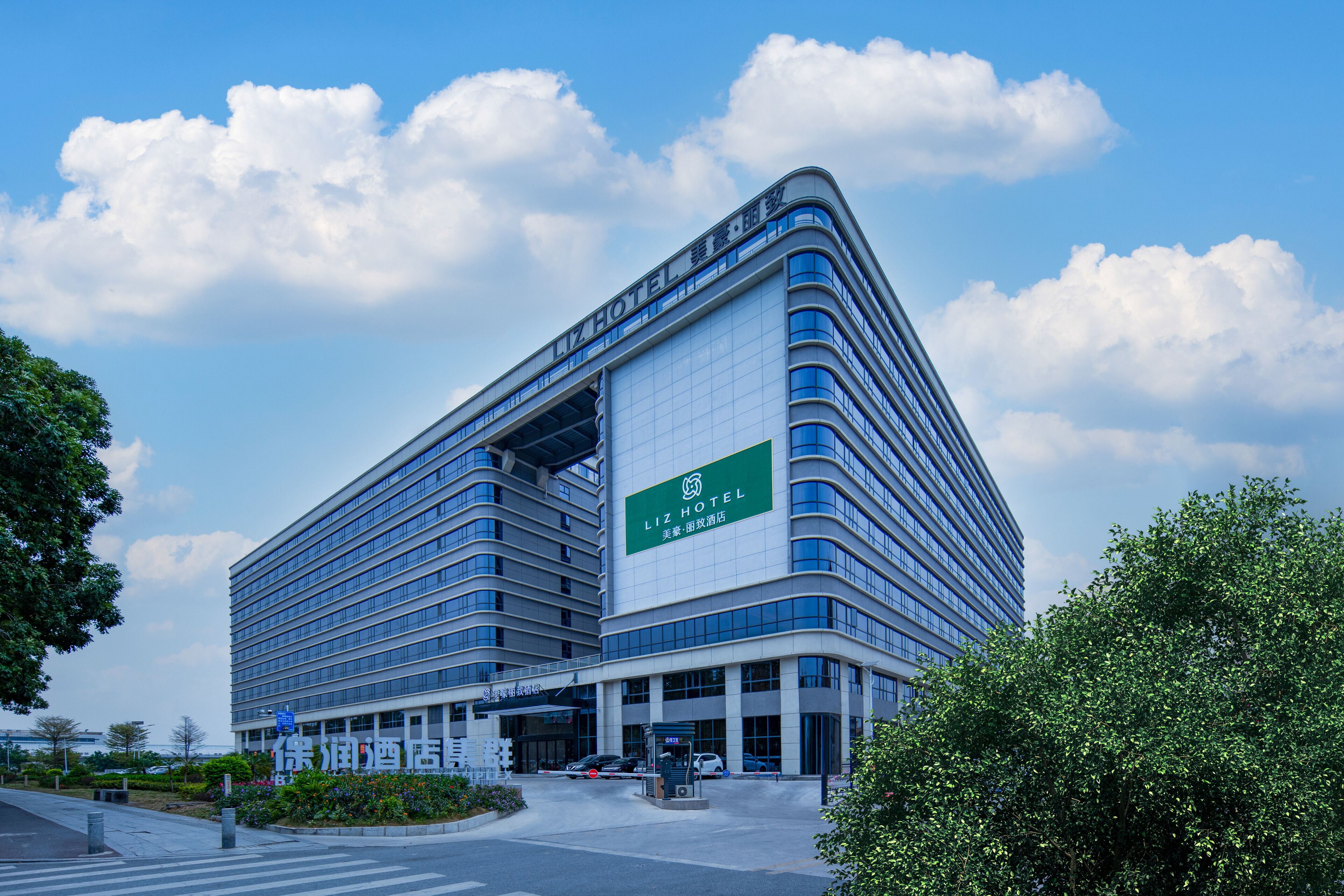 A modern hotel building with a prominent sign, multiple floors, and a large entrance area.