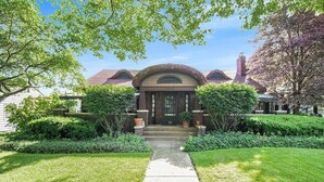 A brick building with a central archway, surrounded by well-maintained lawns and trees. - HOT TUB | Decked Out Oasis | Nespresso Coffee Bar (South Bend)