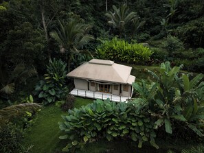 A bungalow with a flat roof, surrounded by lush tropical vegetation. - Nadi Nature Resort - Adults Only (Penebel)