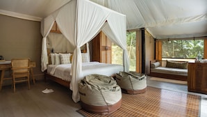 A bedroom with a four-poster bed, a wooden desk, and a seating area with cushions. - Nadi Nature Resort - Adults Only (Penebel)