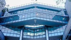 Un bâtiment moderne doté d’une façade en verre, de plusieurs étages et d’une architecture aux lignes angulaires originales.