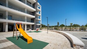 A multi-story building with a playground area featuring a yellow slide. - WePuglia - LOI20 - Apt Maestrale (Monopoli)