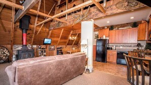 Ein gemütliches Blockhaus-Interieur mit Wohnbereich, Küche und Kamin.