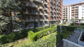 A multi-story residential building with balconies, a well-maintained garden, and a clear sky. - notaMI - Twins Apartment  (Milan)