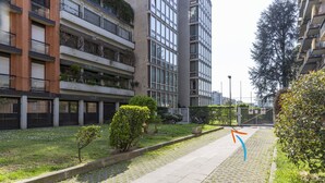 A residential building with multiple balconies, a paved pathway, and a small garden area. - notaMI - Twins Apartment  (Milan)