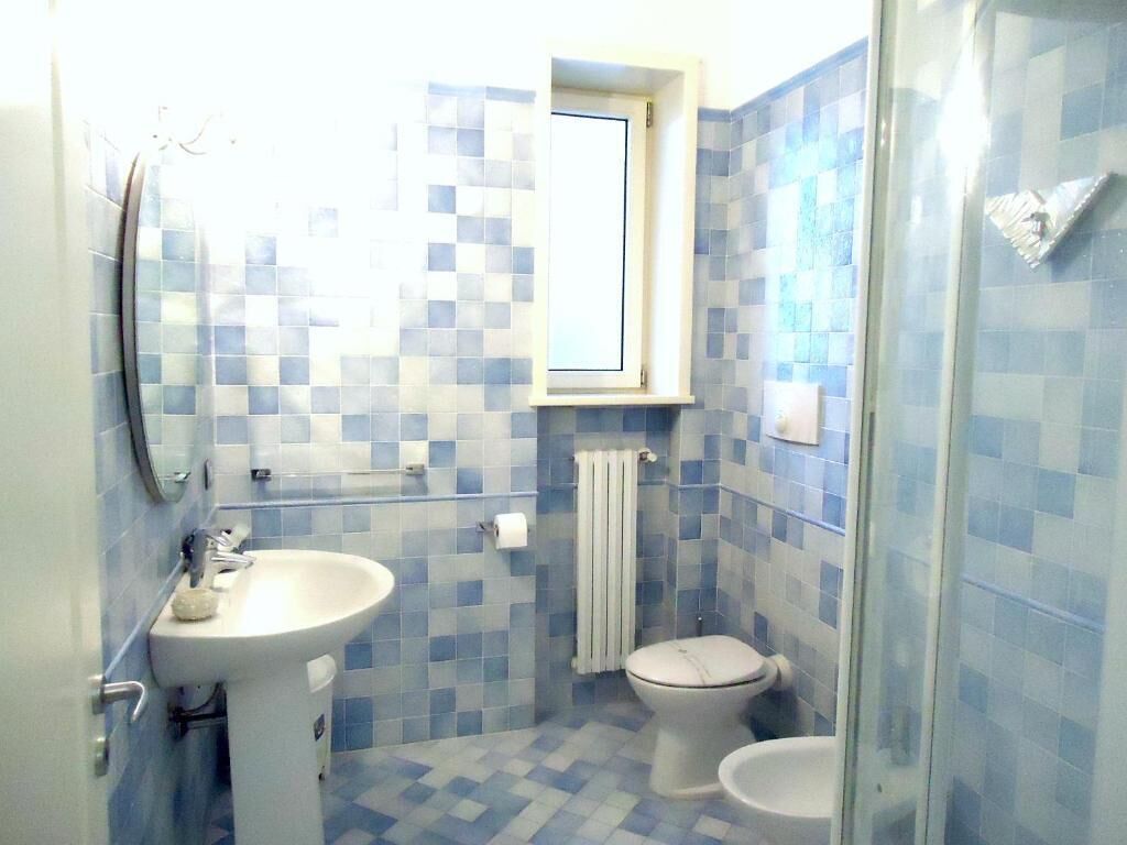 Un bagno con lavandino, WC e zona doccia.