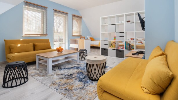 A modern living room with a sofa, coffee table, and a bookshelf. - Comfortable Studio in Puck | Parking and 400 m to the Beach (Puck)